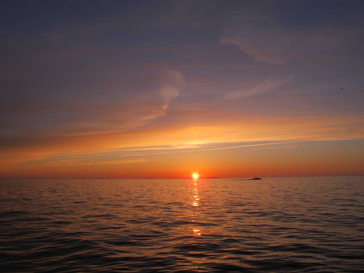 Auringonlaskumaisema merellä Vrow Maria -kauppa-aluksen hylyn yläpuolella.