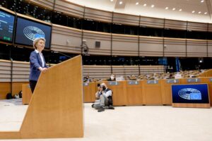 Euroopan komission puheenjohtaja puhuu puhujapöntössä kameramiehen ottaessa kuvaa.