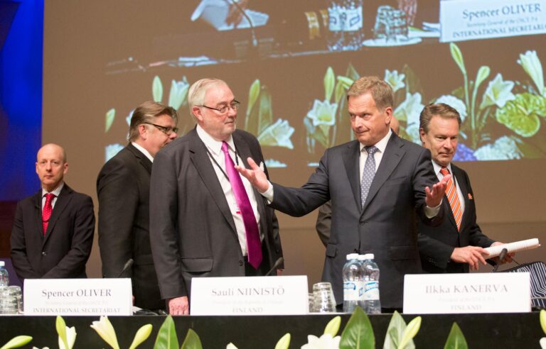 Presidentti Niinistö nostaa käsiään Finlandia-talon lavalla Etyjin yleiskokouksessa.