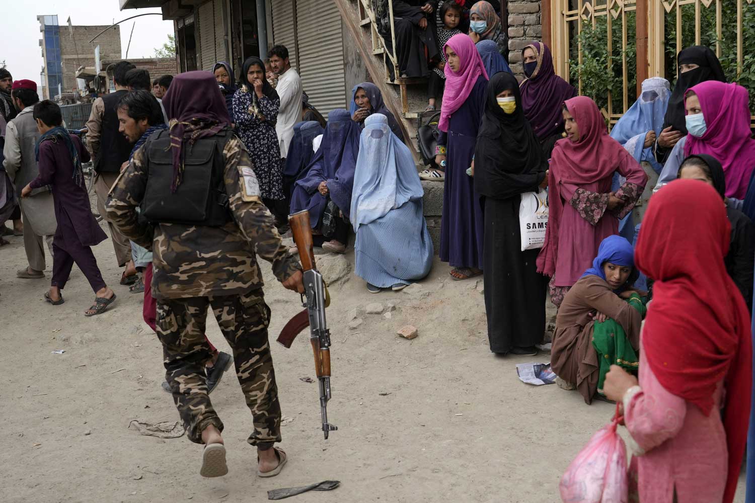 Naisia jonottaa ruoka-apua aseistetun taliban-sotilaan vartioidessa