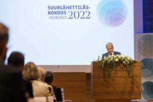 Presidentti Niinistö puhuu puhujakorokkeella yleisön edessä. Taustalla näkyy suulähettiläskokouksen logo.