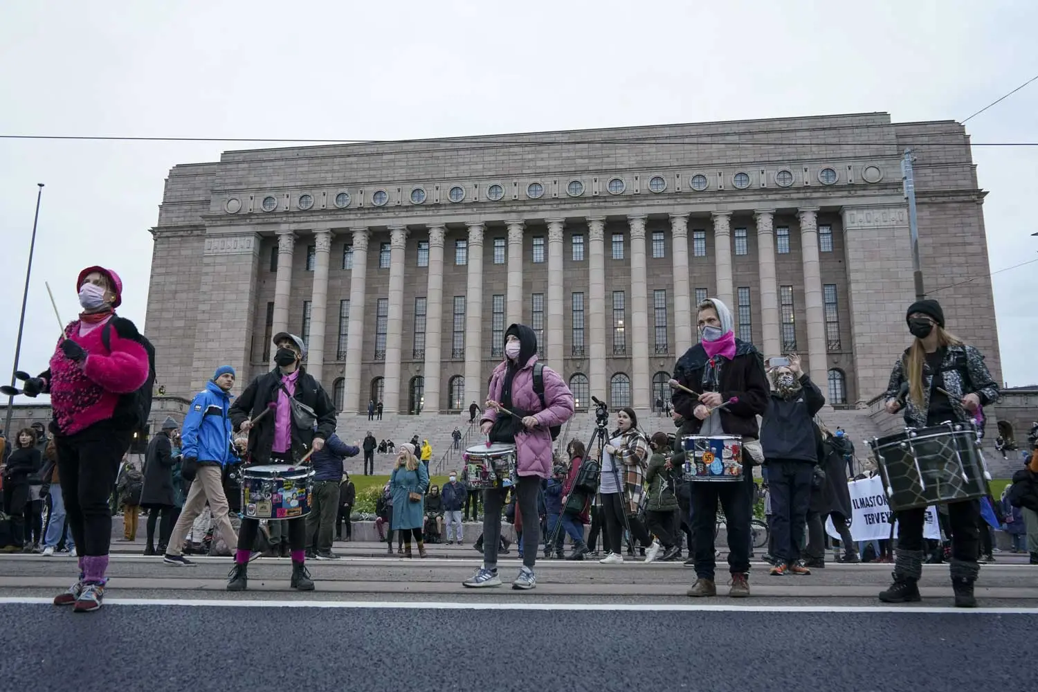 Eduskuntatalon edessä Elokapinan mielenosoittajia, joista osalla on soitettavanaan rummut.