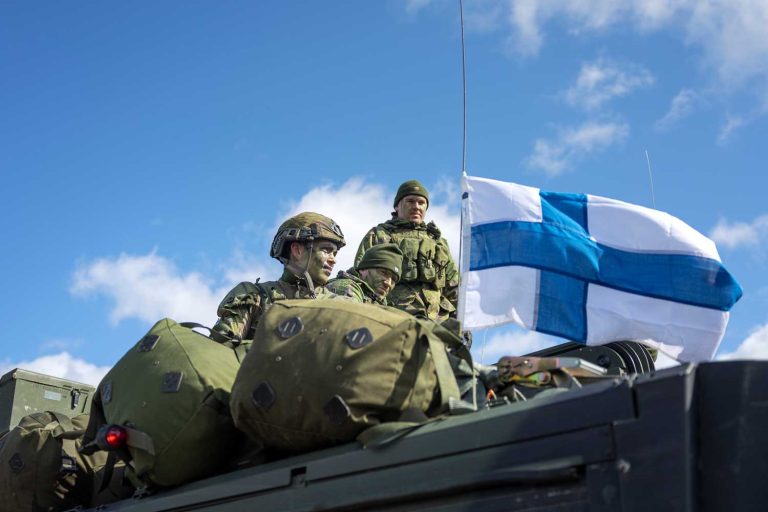 Finlands flagga och tre soldater.