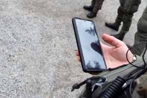 Sotilas pitää kädessään puhelinta, jolla käytttää Instan Blue Tracker -sovellusta.