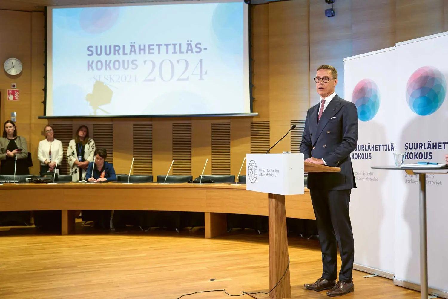 Presidentti Stubb puhuu puhujakorokkeen takana. Taustalle heijastettuna otsikko Suurlähettiläskokous 2024.