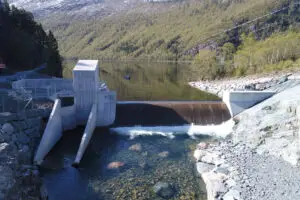 Vesi virtaa patorakennelman läpi vuonomaisemassa.