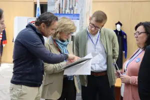 Neljä henkeä tarkastelee asiakirjoja vaalipaikalla.