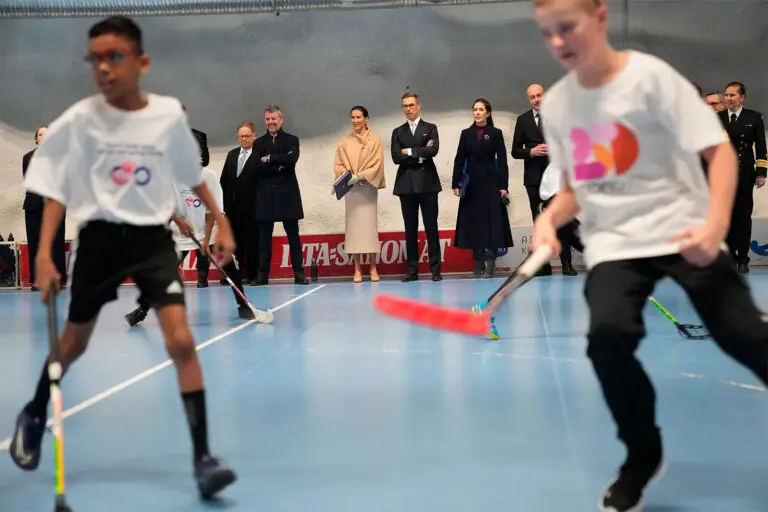 Tanskan kuningaspari ja Suomen tasavallan presidentti puolisoineen seuraavat kuvan etualalla käynnissä olevaa lasten sählypeliä.